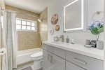 Hallway full-bathroom utilizes spacious vanity to reduce clutter